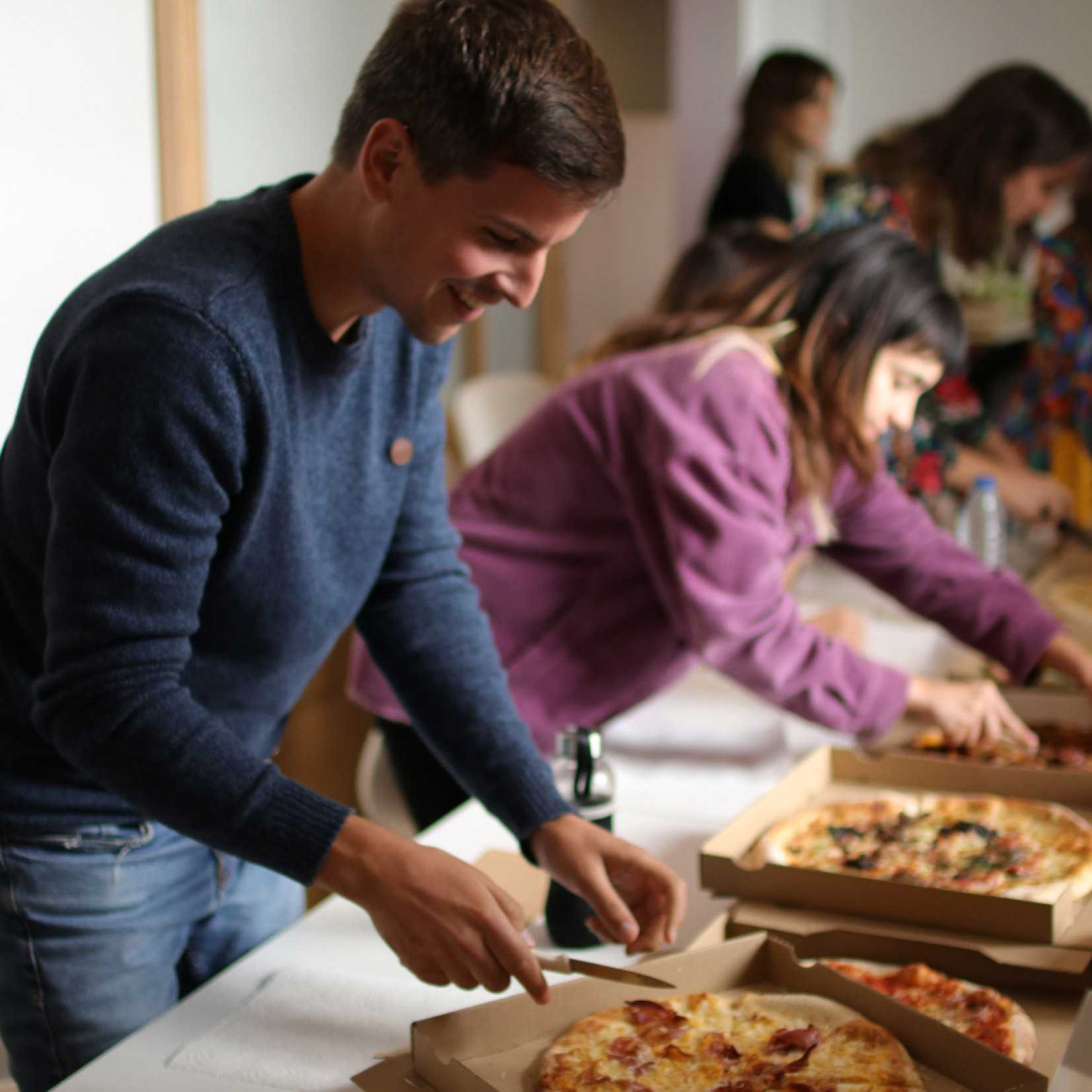 Equipo Worköholics cortando pizza